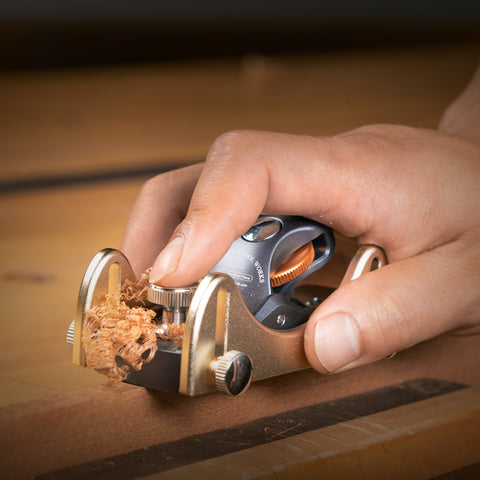 Hand using a cork removal tool on a wooden surface