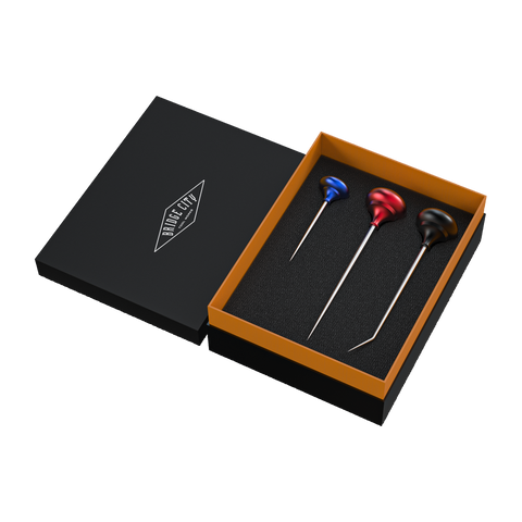 A set of three scratch awls with colored handles displayed in an open black box with an orange lining. The awls are tools used for precise hole layout and starting screws in 