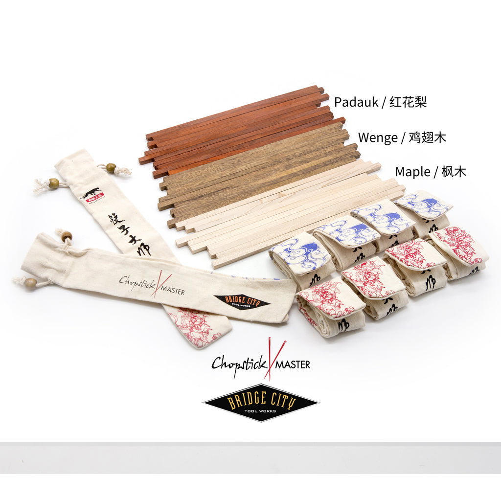 A set of chopstick making materials including wooden blanks in Maple, Paduak, and Wenge, along with canvas sleeves in blue and red, displayed on a table.
