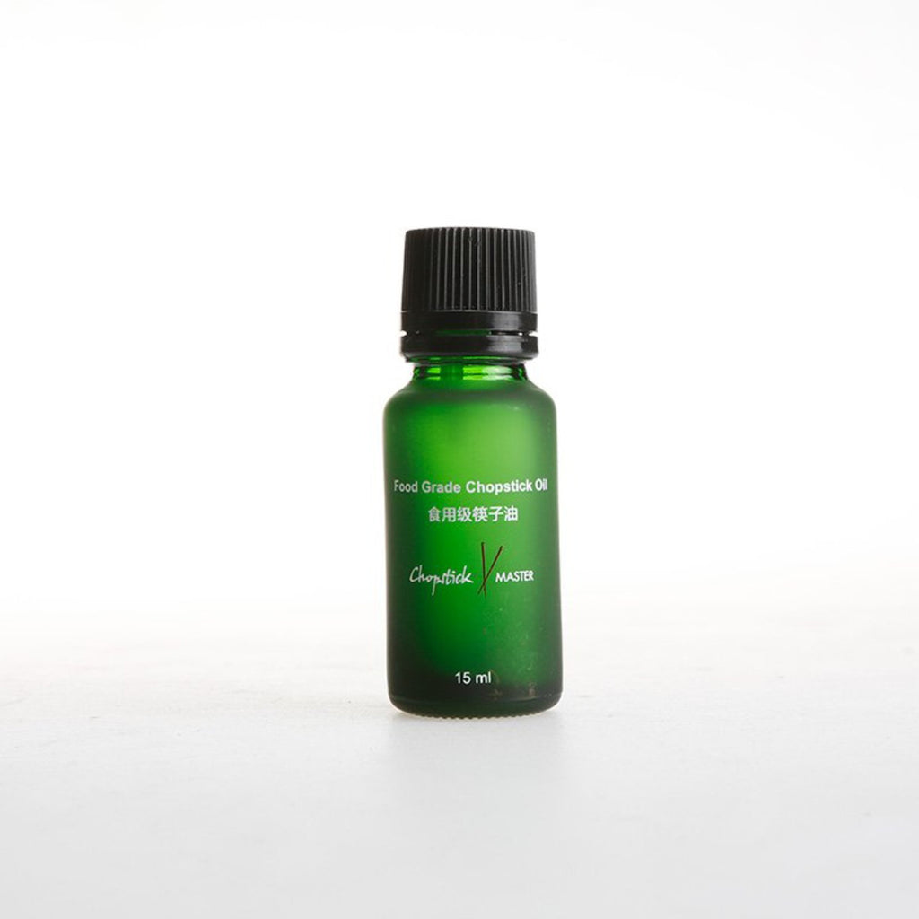 An empty 15 ml green glass bottle with a black cap, labeled for storing food grade oil.