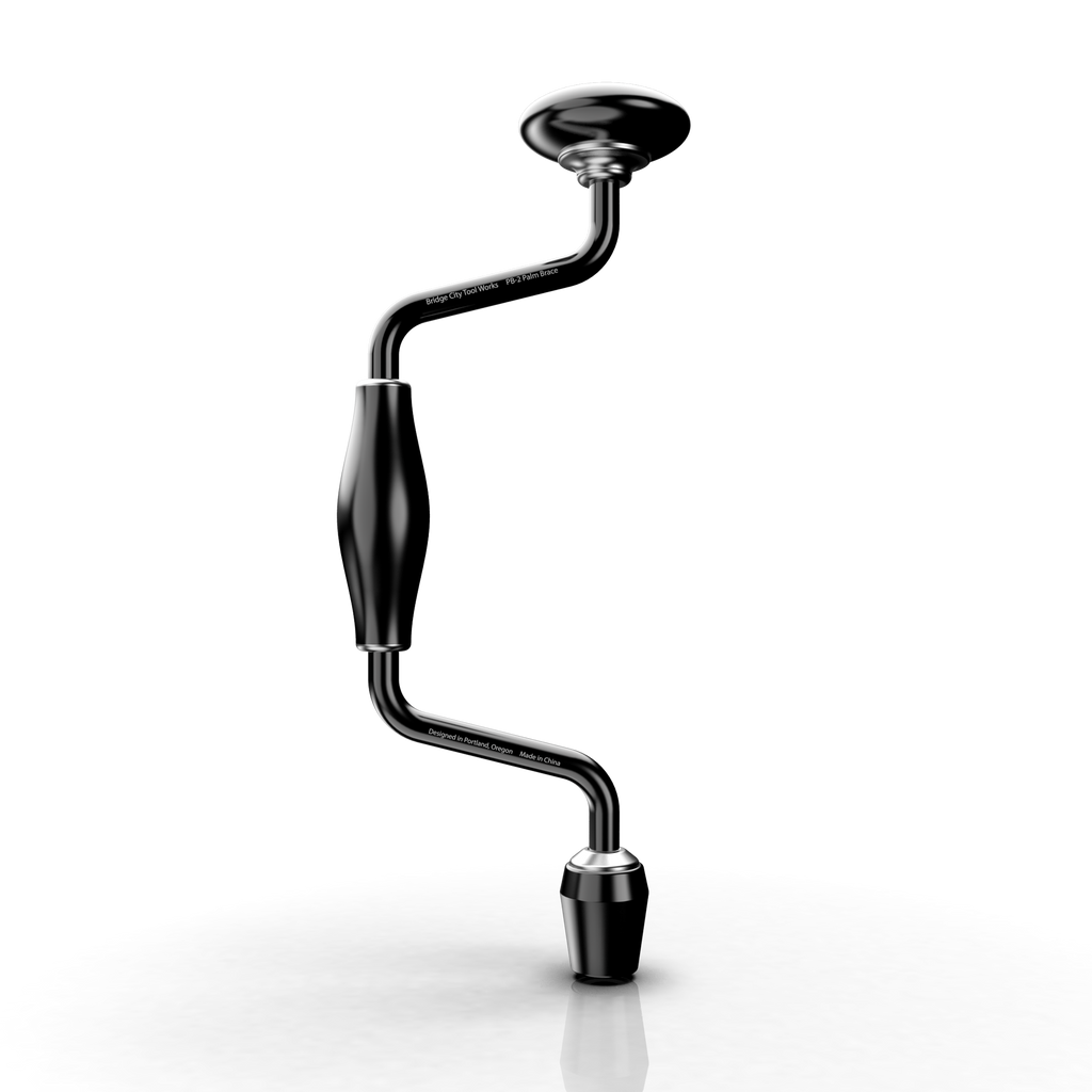 A black and silver PB-2 Palm Brace tool positioned vertically on a reflective surface.