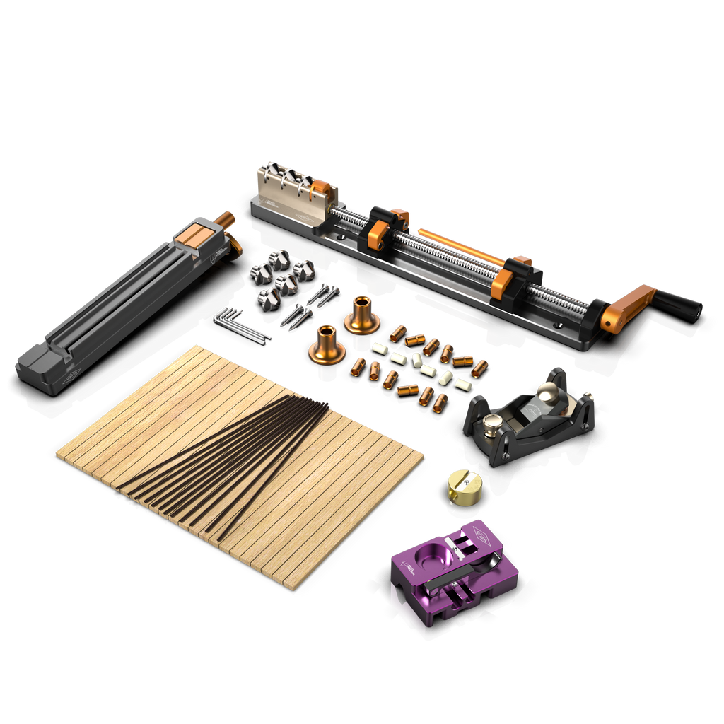 An array of pencil making tools and materials laid out on a table, including a plane sled unit, ferrule unit, and other components of the Pencil Precision kit.